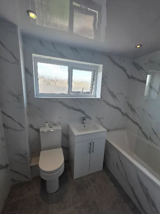 Marble-effect bathroom with bath, vanity and WC